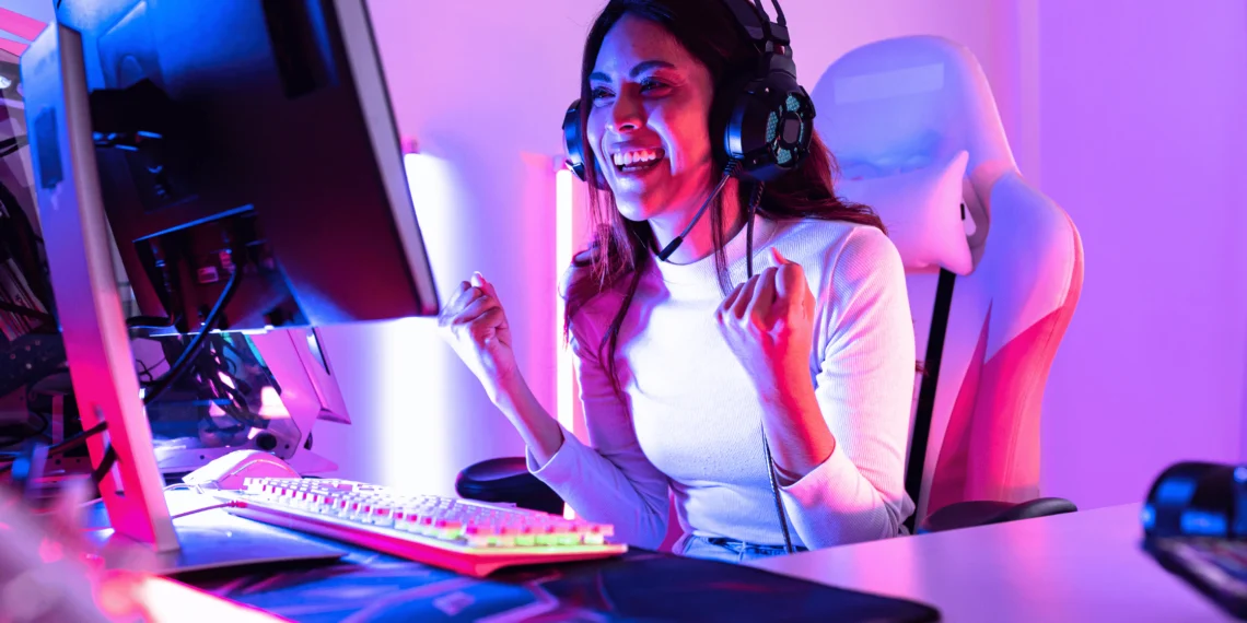 Gamer feliz usando um headset gamer barato em um setup colorido.