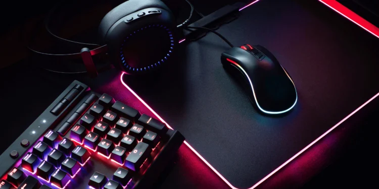 Setup gamer com teclado, fone de ouvido, mouse e mouse pad com iluminação RGB.