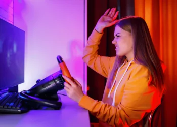 Mulher frustrada tentando configurar os pedais do volante Leadership Gamer em um computador.