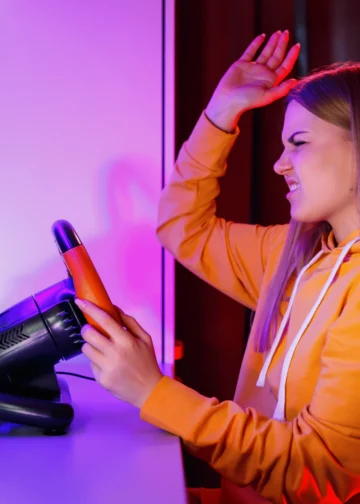 Mulher frustrada tentando configurar os pedais do volante Leadership Gamer em um computador.