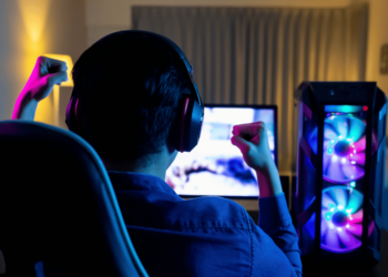 Os 10 Melhores Gabinetes Gamer Atualmente! 4 Gamer em sua estação de jogos com um dos melhores gabinetes gamer iluminados.
