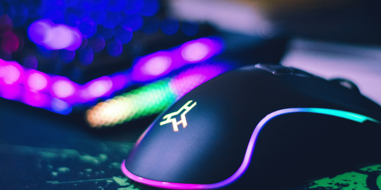 Imagem de uns dos Melhores Mouses Gamer sem Fio com iluminação RGB, destacado em um ambiente de jogo com um teclado RGB ao fundo.