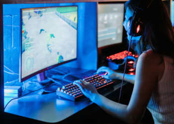 Melhor Monitor Gamer: os 7 melhores em 2024 7 Jogadora usando o melhor monitor gamer em ambiente de jogo.