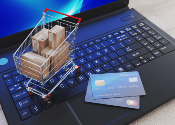 As Melhores Lojas Digitais de Jogos para PC e Video Games! 6 Carrinho de compras sobre um teclado de laptop, simbolizando compras digitais de jogos para PC e consoles.