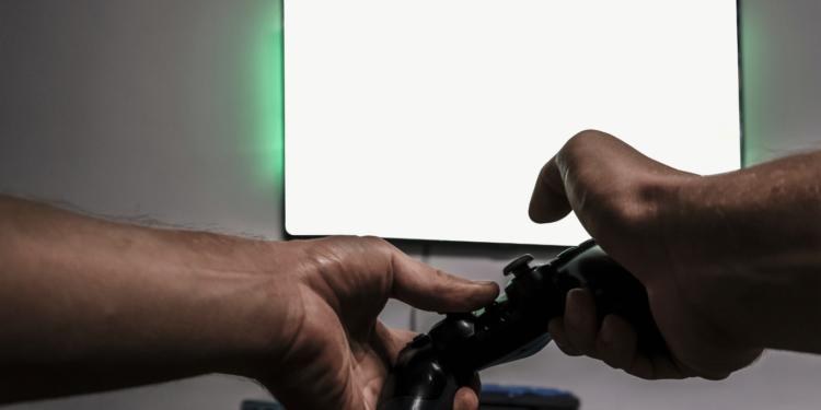 Comparação entre Xbox series x VS Ps5 mostrando um jogador segurando um controle.