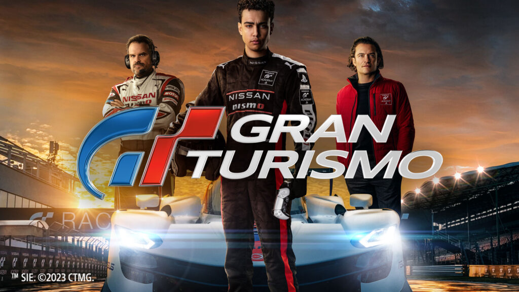 Pôster oficial do filme Gran Turismo com três protagonistas à frente de carros de corrida.